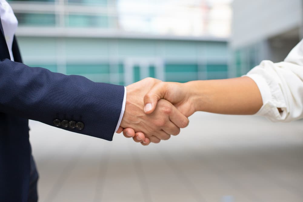 Handshake representing lice removal partnerships for schools and institutions